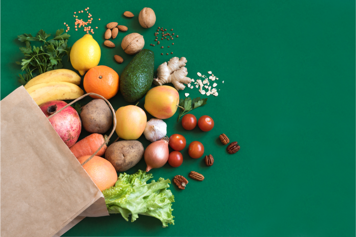 L'image représente un sac de courses rempli de produits bio, fruits et légumes. Manger bio pour un bien-être naturel