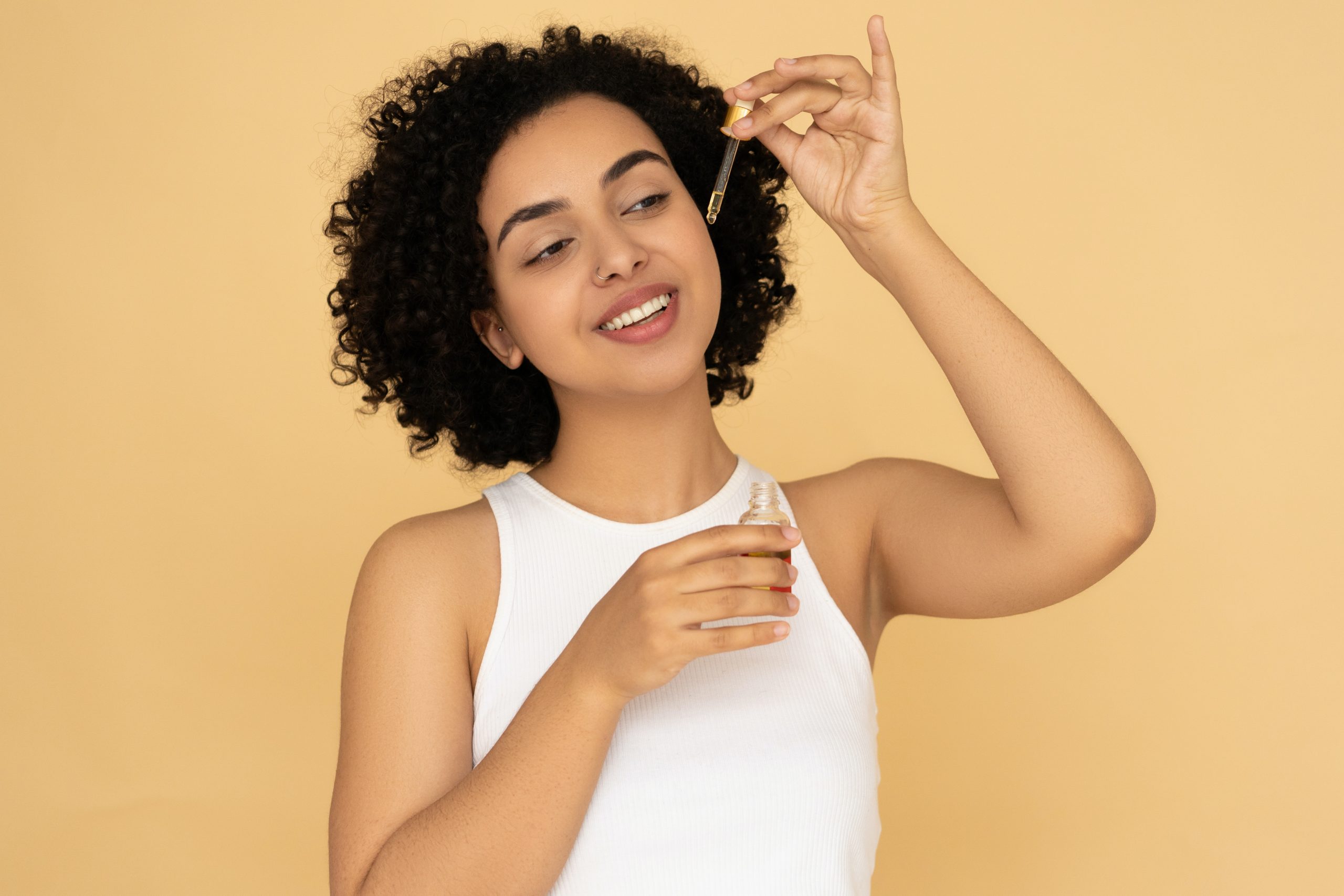 la photo montre une femme qui applique de l'huile d'onagre sur sa peau.