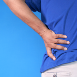 La naturopathie au service de l'hernie discale. une personne qui a les mains sur le bas du dos. sur fond bleu
