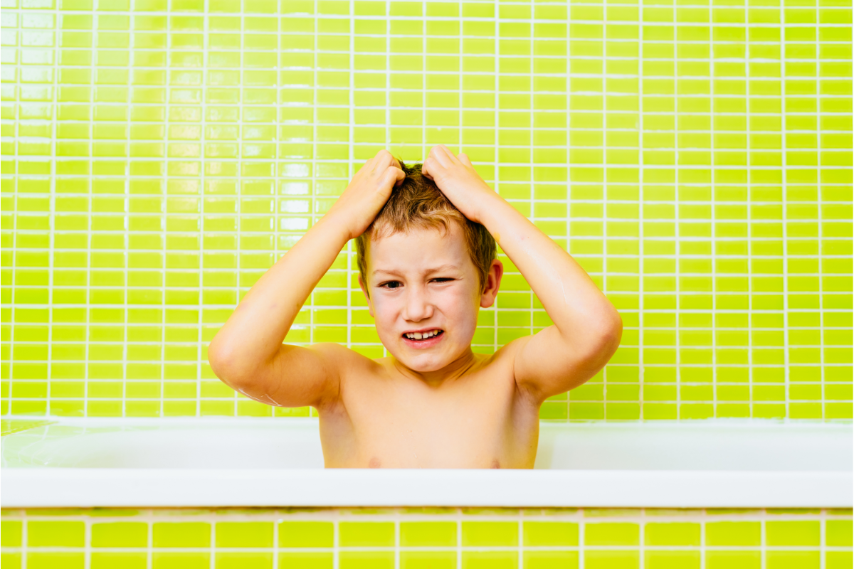 un enfant dans une baignoire qui se gratte la tete. Poux de l'été : les différentes solutions pour les éviter sur la plage