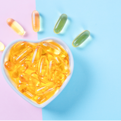 Une image montre un bol en forme de cœur rempli de capsules dorées d'oméga 3, entouré de quelques capsules vertes et dorées d'oméga 6, illustrant l'importance d'un équilibre adéquat entre ces acides gras essentiels pour la santé cardiovasculaire et le bien-être général.