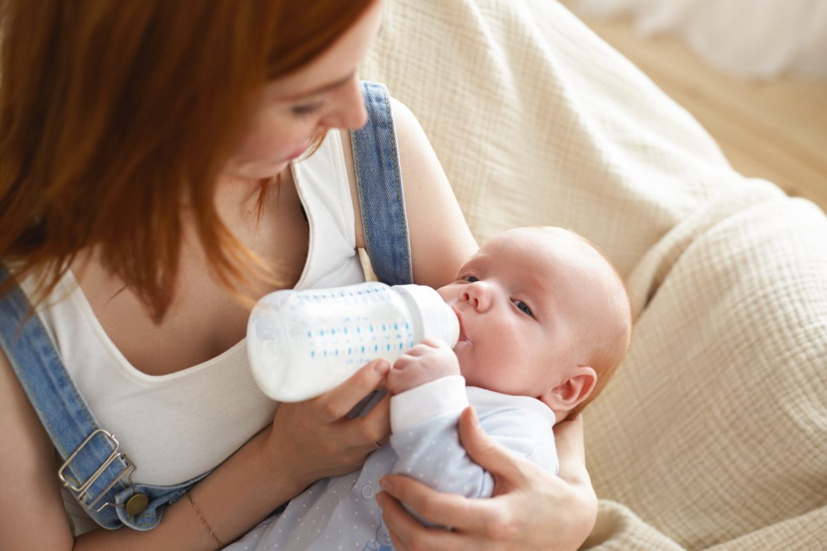 un enfant qui boit son lait, une maman qui donne le biberon a son bébé