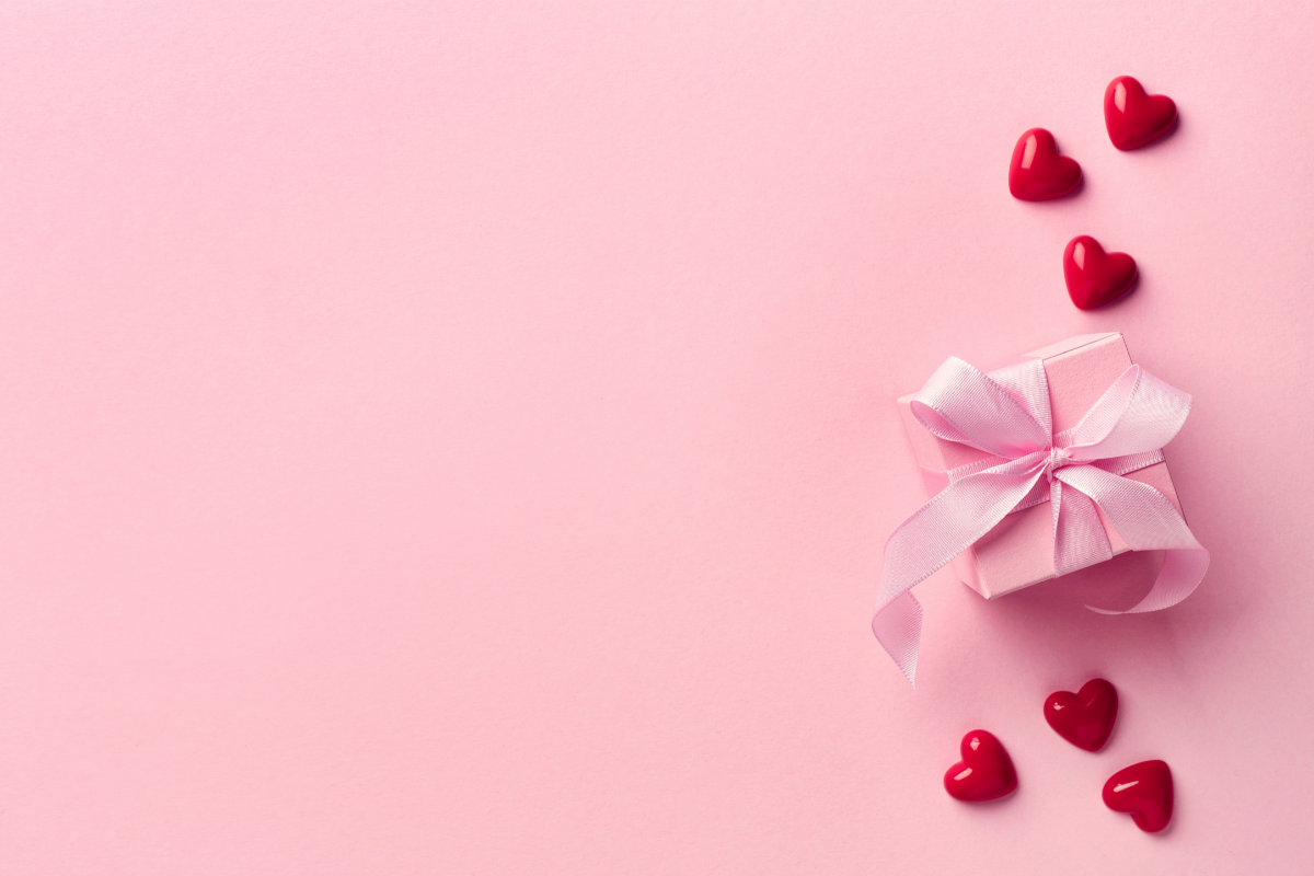 L'image représente un gros nœud rose, avec des jolis cœurs, sur un fond rose. À la recherche du cadeau parfait pour la Saint-Valentin