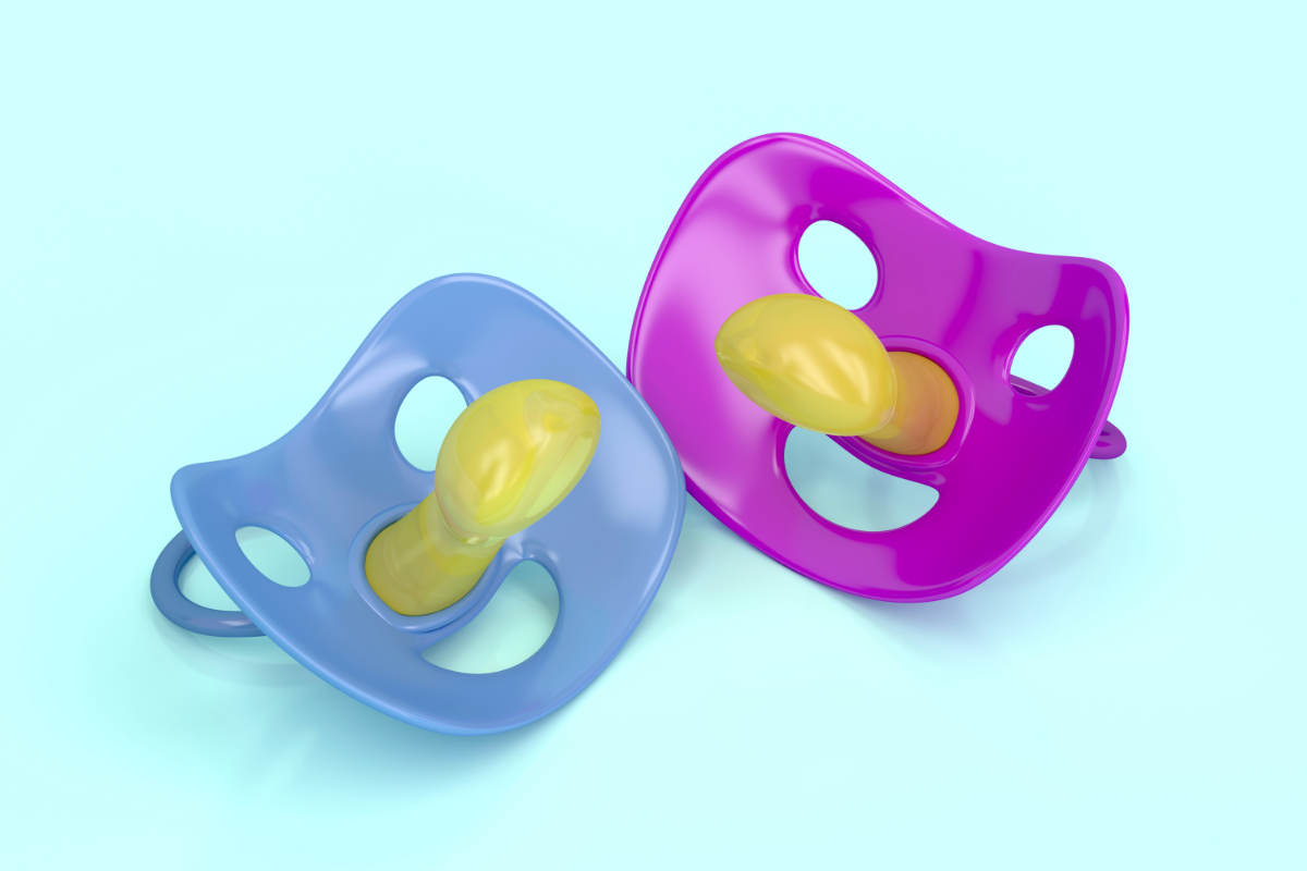 Deux sucettes pour bébé, l'une bleue et l'autre rose, sont disposées côte à côte sur un fond bleu clair. Ces sucettes ont des boucliers de forme orthodontique avec trois trous de ventilation et des tétines en silicone jaune. La forme de la tétine est conçue pour s'adapter au palais du bébé, avec une courbe naturelle qui respecte le développement bucco-dentaire. Ces sucettes sont conçues ergonomiquement pour le confort et la sécurité des nourrissons.