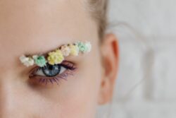 une femme maquillée avec des fleurs dans les sourcils