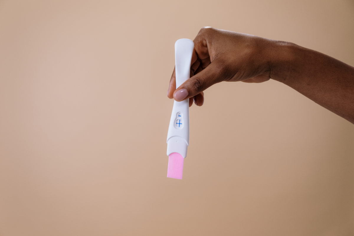 L'image représente une main qui tient un test de grossesse positif. Voici quelques solutions pour le mal de dos pendant la grossesse. La photo représente une main qui tient un test de grossesse