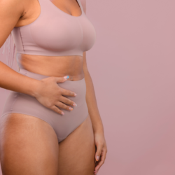 L'image représente une femme en sous vêtement qui se touche le bas ventre comme si elle avait des douleurs liées au SOPK. Un guide pratique sur comment gérer le SOPK grâce à la naturopathie