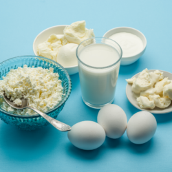 Faut-il Consommer Plus de Protéines en Vieillissant. L'image représente différentes sources de protéines sur une table bleue: des peurs, du cottage cheese, du lait ...