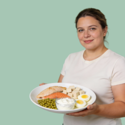 Femme tenant une assiette composée d’aliments riches en protéines comme le saumon, les œufs, le tofu et les légumineuses, illustrant une alimentation protéinée équilibrée pour la perte de poids.