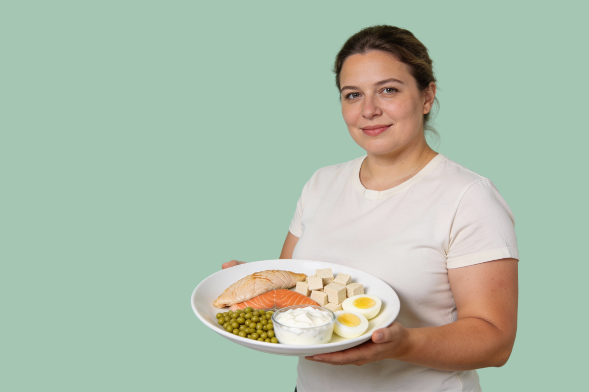 Femme tenant une assiette composée d’aliments riches en protéines comme le saumon, les œufs, le tofu et les légumineuses, illustrant une alimentation protéinée équilibrée pour la perte de poids.