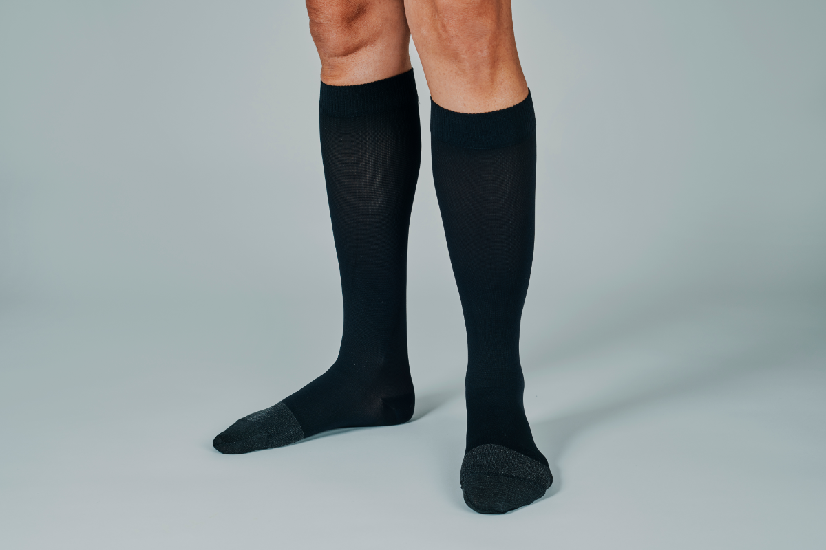l'image représente une personne qui porte des chaussettes de contention pour soulager son eczéma variqueux ou dermite de state