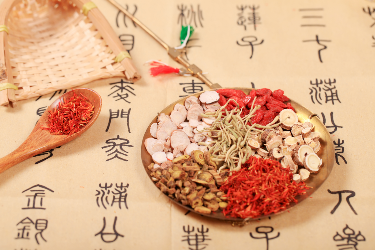 drogues végétales issues de la Pharmacopée Chinoise dans un bol en bois, posé sur une prescription en chinois