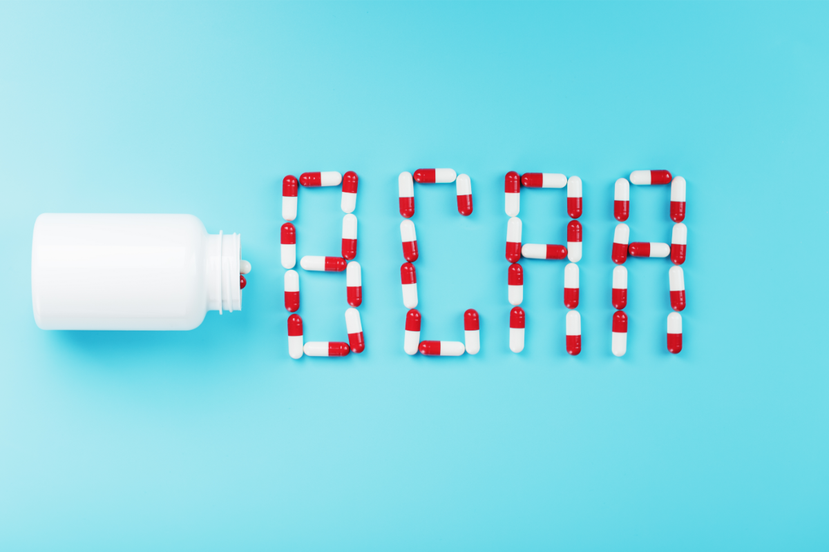 L'image représente un flacon de BCAA acheté en pharmacie qui se renverse. Les gélules rouge et blanche forment le mot BCAA sur un fond bleu.