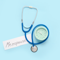 un stéthoscope et un mot qui dit " ménopause", pour illustrer les symptômes de la ménopause comme les bouffées de chaleur, sueurs nocturnes ou encore la sécheresse vaginale.