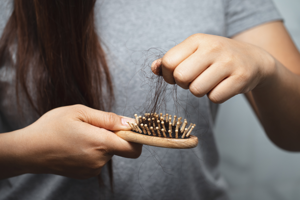 femme enlevant des cheveux d'une brosse