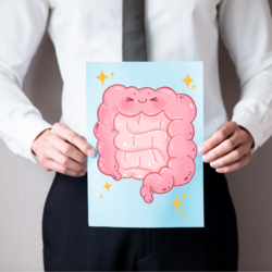 Un hombre trajeado sostiene una ilustración de un intestino sonriente, símbolo de la importancia de la microbiota intestinal para la salud en general.