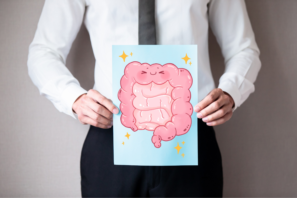 Un homme en costume tenant une illustration d’un intestin souriant, symbolisant l’importance du microbiote intestinal pour la santé globale.