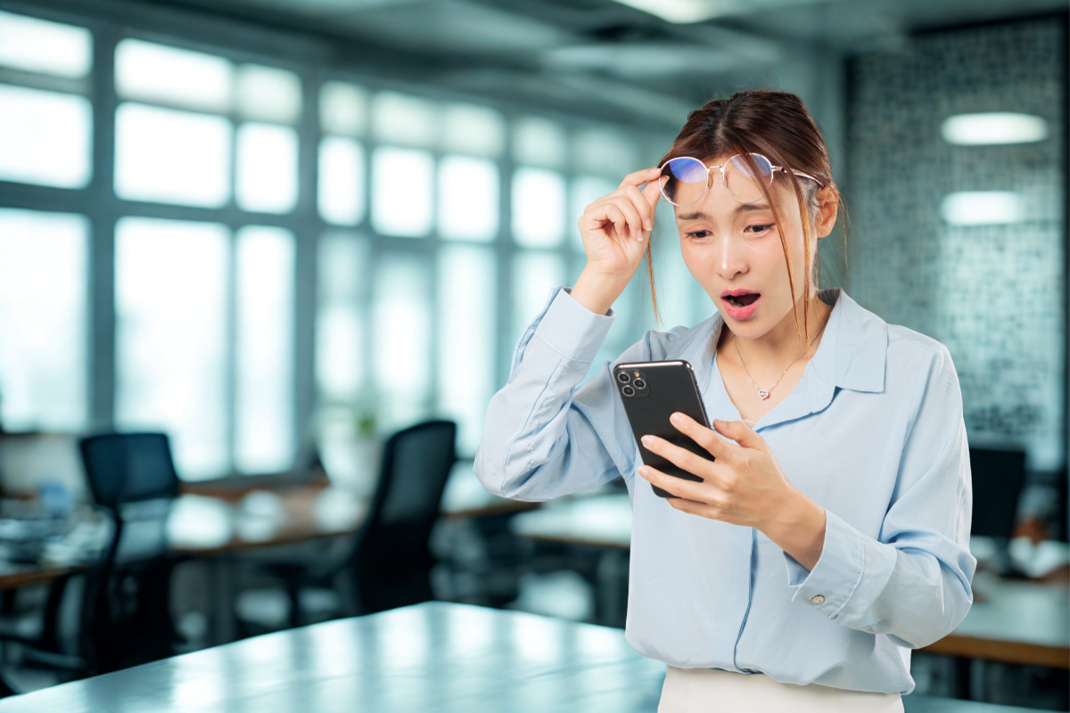 Femme surprise par une baisse de la vision en regardant son smartphone