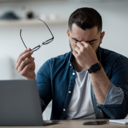Homme souffrant de yeux secs et de fatigue oculaire après un travail prolongé sur écran