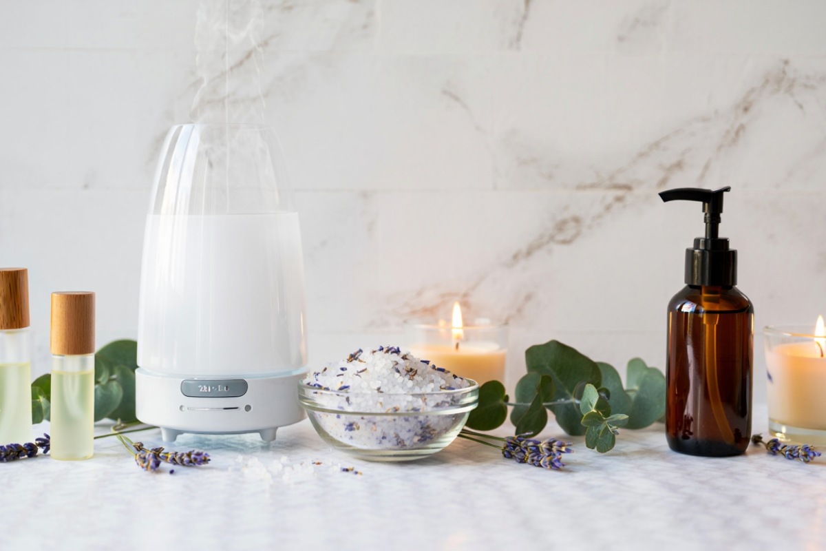 Diffuseur d’huiles essentielles avec vapeur aromatique, flacon d’aromathérapie, sels de bain et plantes pour une utilisation des huiles essentielles en diffusion et bien-être.